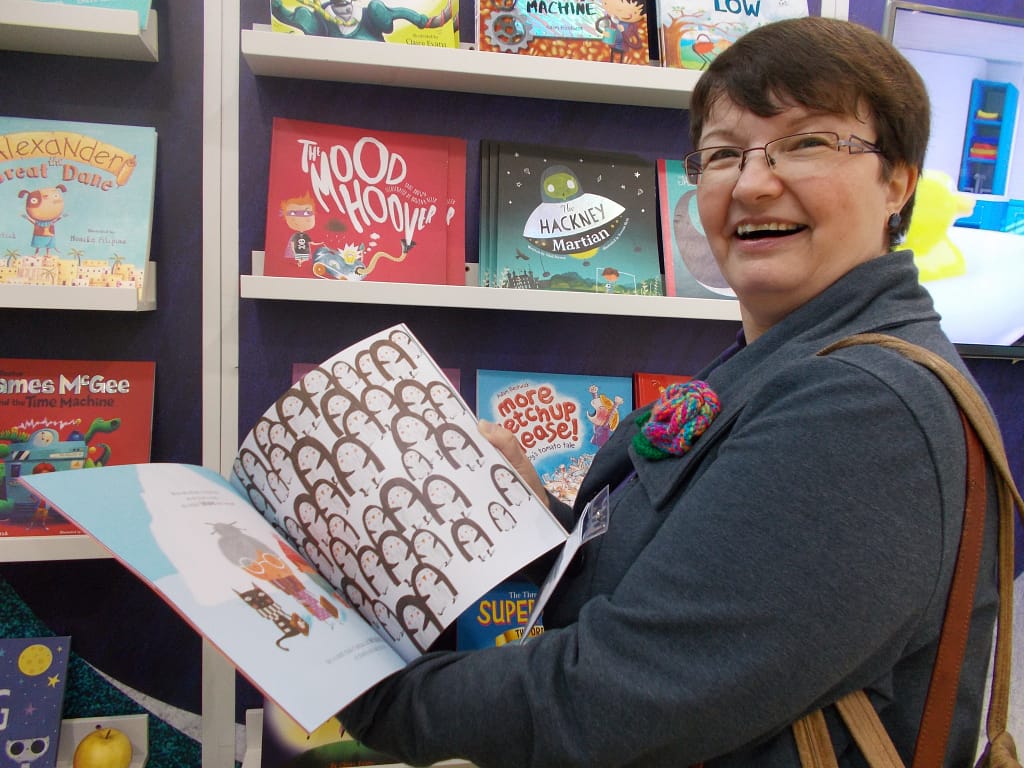 Lynda overjoyed at the image of many penguins in a picture book