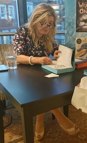Cressida Cowell signing a copies of her books